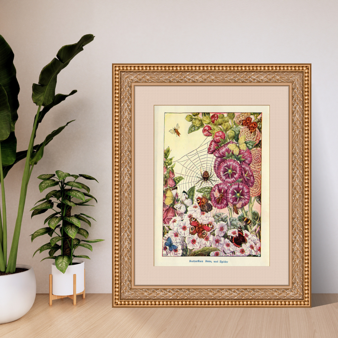 Framed botanical illustration of flowers and insects on a wall with plants in the background.