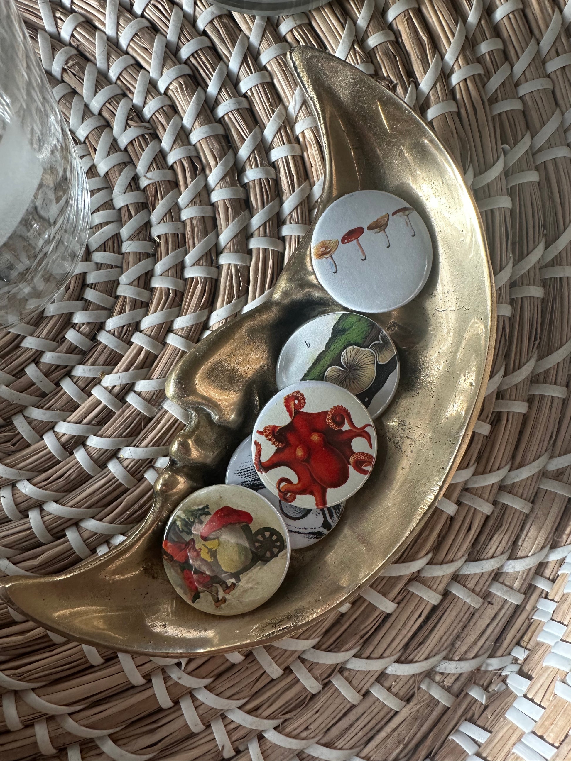 Decorative tray with colorful buttons with quirky vintage illustrations on a woven surface
